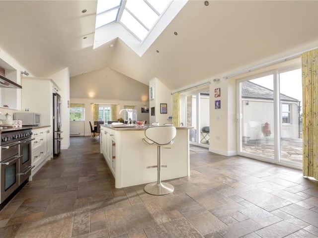 The kitchen is fitted with traditionally styled units and has a central island with breakfast bar.