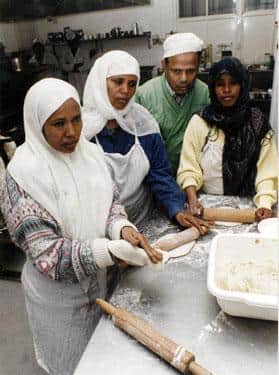 Group of women making chapattis at the Pakistan Muslim Centre, Woodbourn Road in 1993.