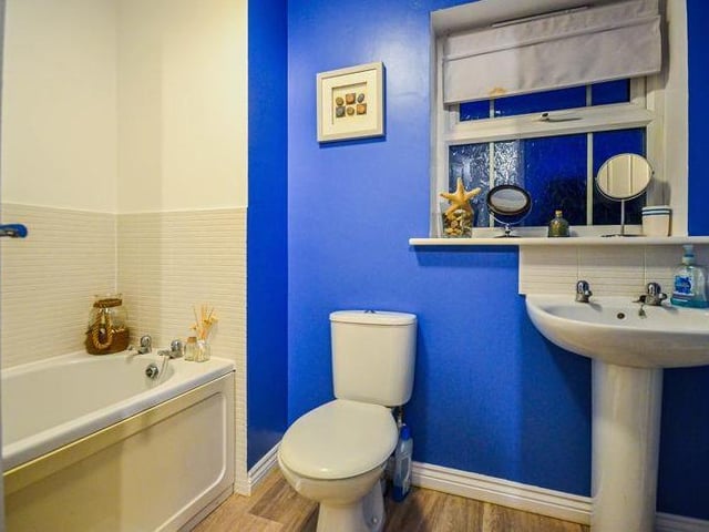 The family bathroom features a bath, low-flush WC and wash hand basin. The room is clean and practical.