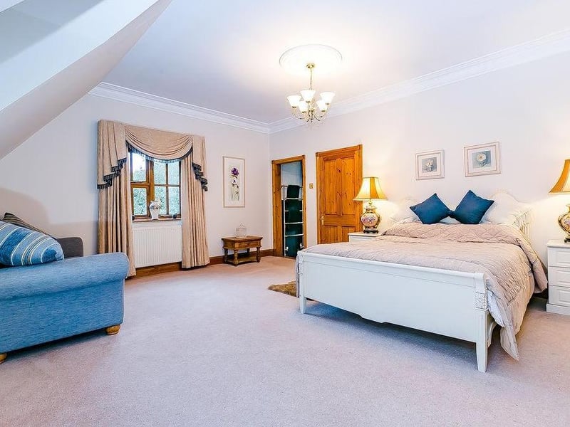 The master bedroom includes a large, walk-in dressing-room. There are also fitted wardrobes running down two sides of the room
