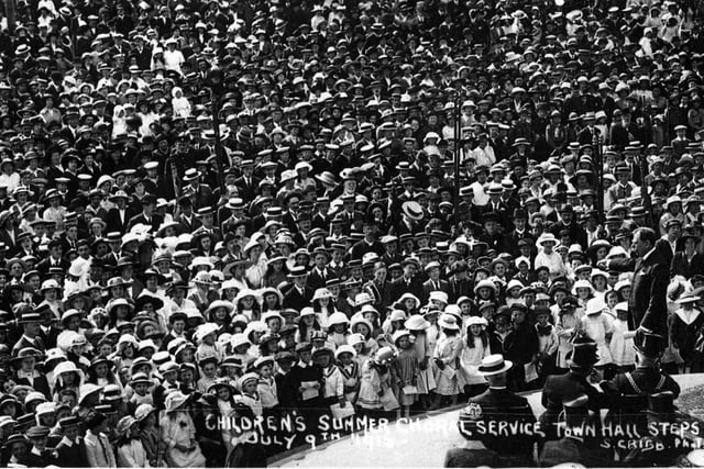 The Children's Summer Choral Service at the steps of the  then Town Hall later the Guildhall. It is July 9 1916. The many hundreds of boys and girls, some in naval uniform ALL wear a hat of some kind. A wonderful photo of a generation now all gone.