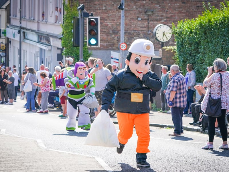 Competitors in the Mascot Race take part in the Scottish Coal Carrying Championships through the streets of Kelty in Fife. Picture date: Saturday August 28, 2021. PA Photo. The annual event is one of only two Coal Races in the world and the men's race requires participants to carry a 50-kilo bag of coal and the women's race requires a 25-kilo bag of coal to be carried over 1000 metres through the village. Photo credit should read: Jane Barlow/PA Wire