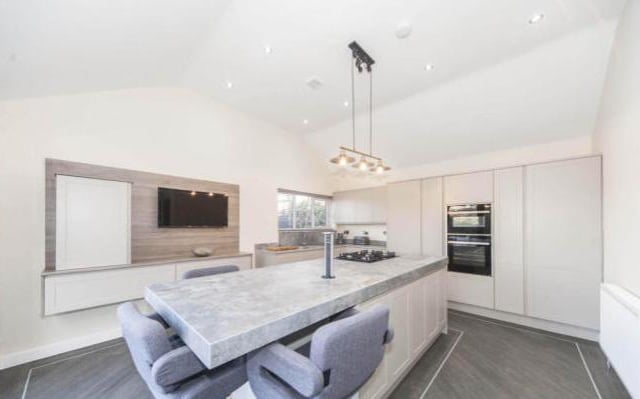 This stunning kitchen has a feature island breakfast bar, excellent array of wall and base cabinets, polished concrete work surfaces, integrated five ring gas hob, integrated wine fridge, integrated double freezer, integrated double fridge, and so much more!