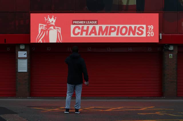 LIVERPOOL, ENGLAND - JUNE 26: A fan takes a picture in front of an electronic board after Liverpool confirmed as Premier League Champions at Anfield on June 26, 2020 in Liverpool, England. Liverpool claim their first championship in 30 years. (Photo by Jan Kruger/Getty Images)