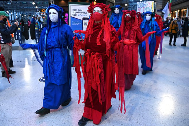 Members of the Red Rebel Brigade - an international performance artivist troupe - arrive at Glasgow Central station.