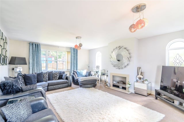 The bright and spacious living room provides a wealth of space for entertaining guests, and benefits from a cosy fireplace at its heart and doors which open out onto the garden.