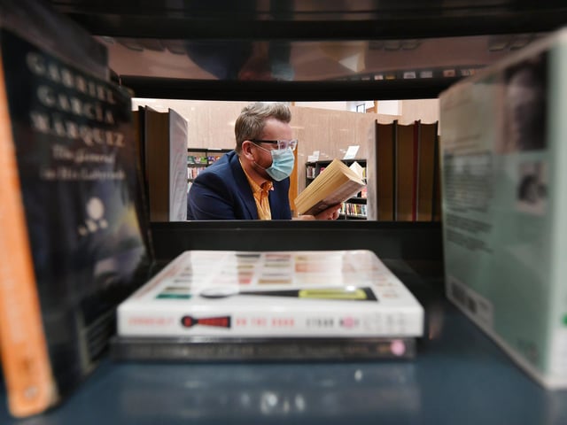 Chair of Glasgow Life,, Councillor David McDonald browsing some books at the Mitchell.