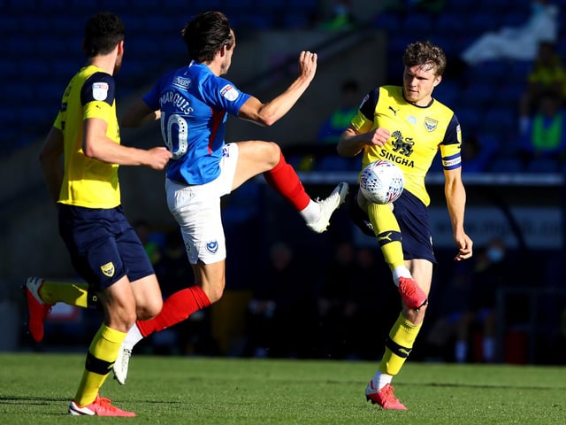 John Marquis is challenged by Rob Dickie of Oxford United