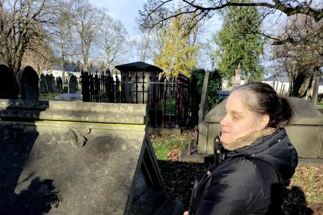 Photo of Carol feeling the lettering on the grave