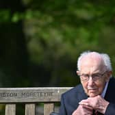 British World War II veteran Captain Tom Moore, 99, does up his tie as he sits on a bench in the village of Marston Moretaine (Photo by JUSTIN TALLIS / AFP) (Photo by JUSTIN TALLIS/AFP via Getty Images)