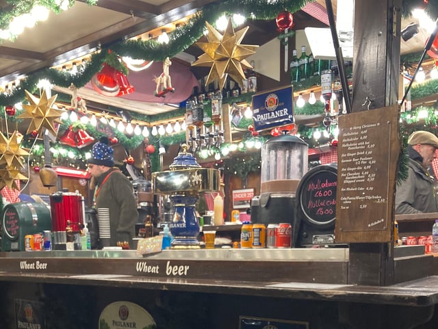 One mulled wine stall at the Edinburgh Christmas Market has decorated beautifully for the season, with garlands of greenery and gold stars hanging from the roof.