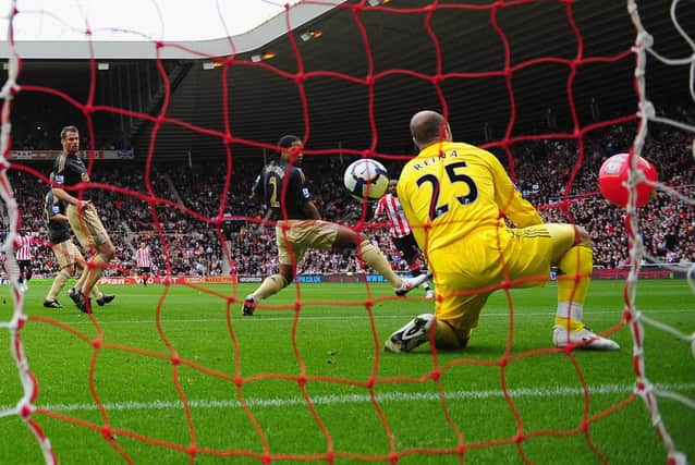 Darren Bent of Sunderland watches as his shot goes between Glen Johnson and Pepe Reina of Liverpool and into the goal off of a beachball