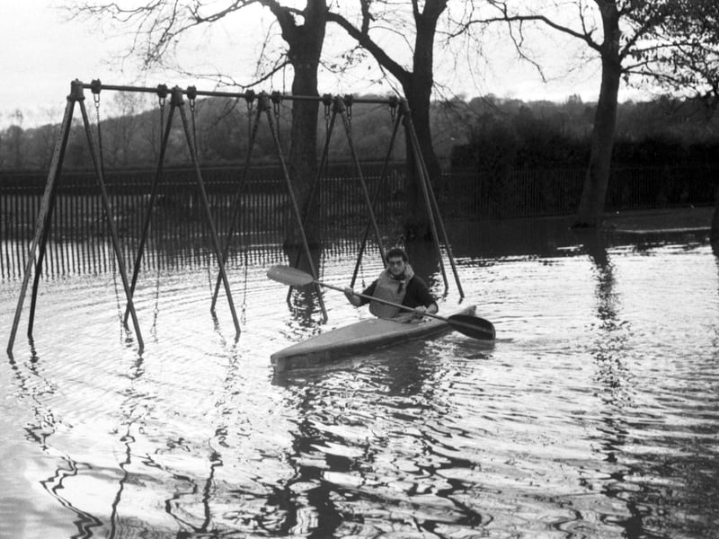 A canoeist paddles through Roseburn Park swing park when the Water of Leith overflowed after flooding in Edinburgh, November 1984.