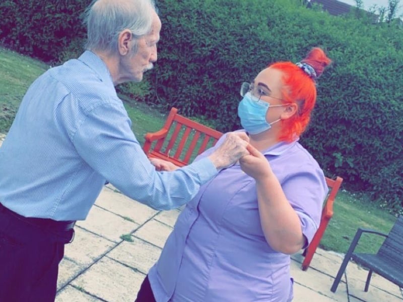 A staff member dancing with a resident.