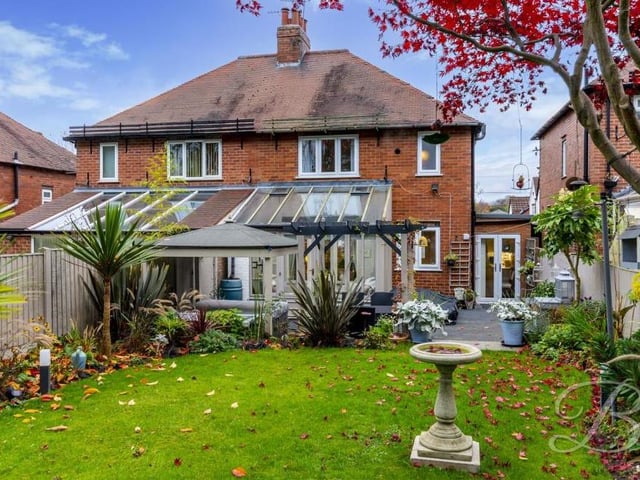 Moving back outside now, and let's take a look at the house from the rear. A sizeable lawn is fenced off, giving a degree of privacy.