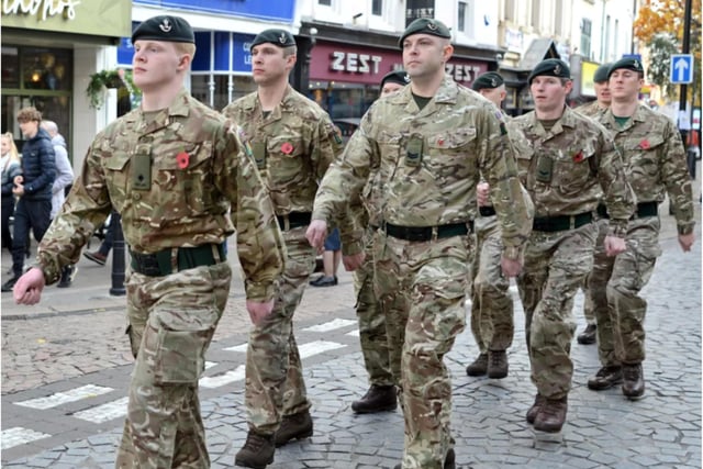 Military personnel marched along the High Street.