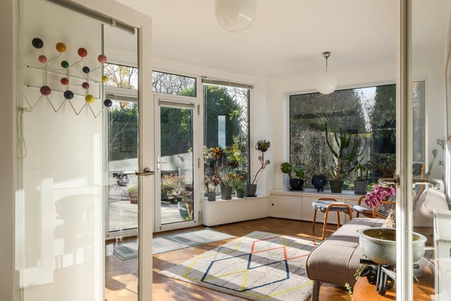 The primary entrance to the property is via this south-facing sunroom, which features floor-to-ceiling glazing on all sides allowing light to flood through, and providing a great spot to look out into the garden.