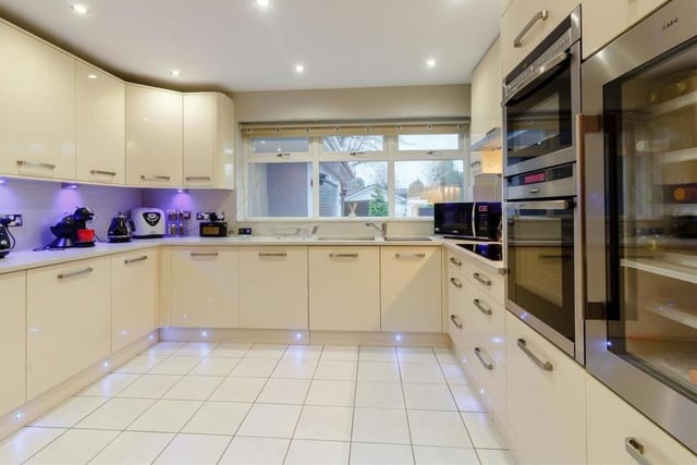 Let's step in to the classy breakfast kitchen now. As you can see, it boasts a comprehensive range of high-quality, contemporary and glossy units in cream, comprising wall cupboards with LED lighting underneath, base units, drawers and granite-effect work surfaces.