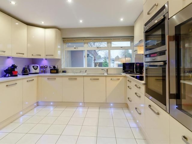 Let's step in to the classy breakfast kitchen now. As you can see, it boasts a comprehensive range of high-quality, contemporary and glossy units in cream, comprising wall cupboards with LED lighting underneath, base units, drawers and granite-effect work surfaces.