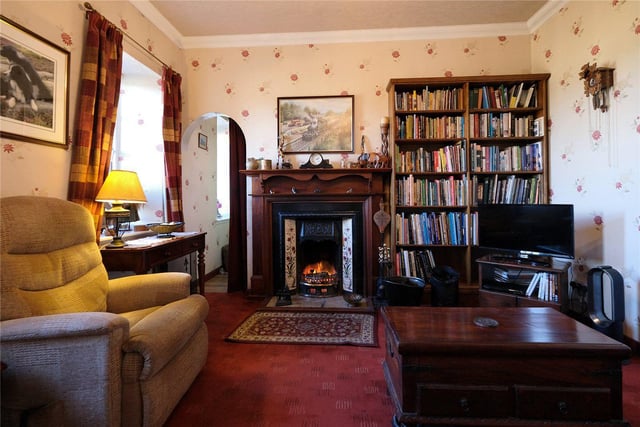 The cosy living room has an open fire.
