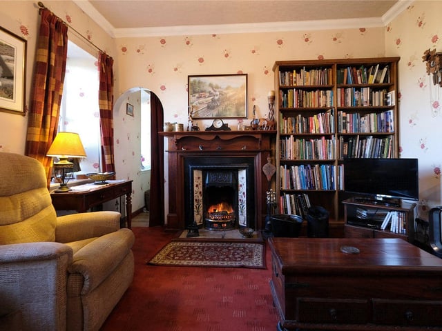 The cosy living room has an open fire.