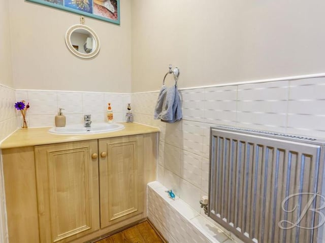 A downstairs toilet always comes in handy. This one features a low-flush WC, wash hand basin, central-heating radiator and an opaque window.