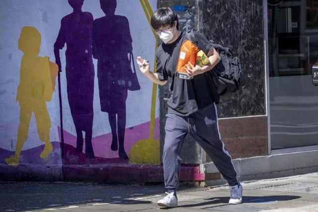 A man wearing a protective face mask carries his shopping in Edinburgh, as people can meet family and friends outdoors and play sports such as golf and tennis again. Photo: Jane Barlow/PA Wire