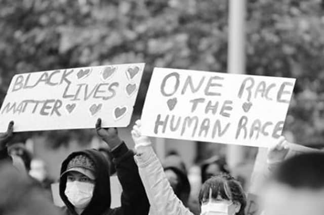 Posters read: "Black Lives Matter, One Race The Human Race."
