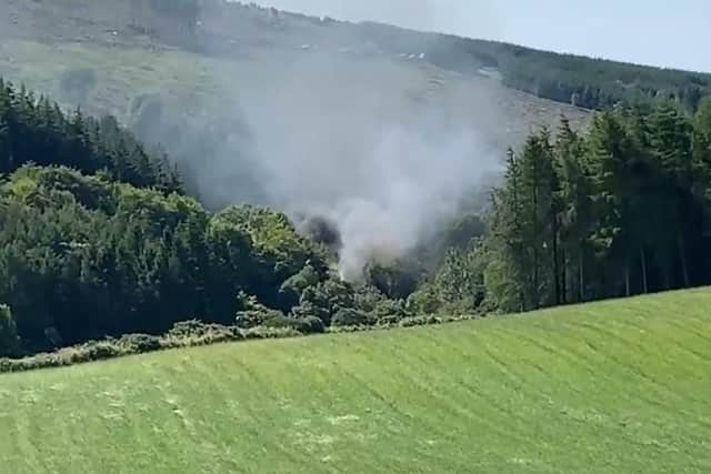 Screen grab from BBC Scotland showing smoke billowing from the train on the track in the countryside near Stonehaven, Aberdeenshire . Emergency services are at the scene after a train derailed in Aberdeenshire. - PA