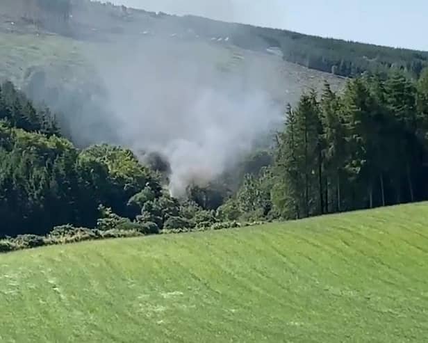 Screen grab from BBC Scotland showing smoke billowing from the train on the track in the countryside near Stonehaven, Aberdeenshire . Emergency services are at the scene after a train derailed in Aberdeenshire. - PA