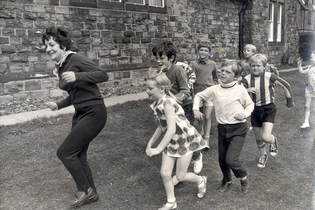 Mrs Margaret Andrews leads a game of "follow my leader" at the Eagle Youth club, Newbold ,Chesterfield during a play scheme...Aug 9th 1971