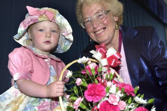 Two-year-old Mellisa Oliver hands over a basket of flowers to Berly Roberts at a Summer Fayre in 2000.