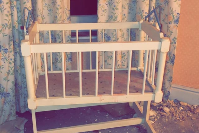 An empty cot stands deserted in one of the bedrooms.