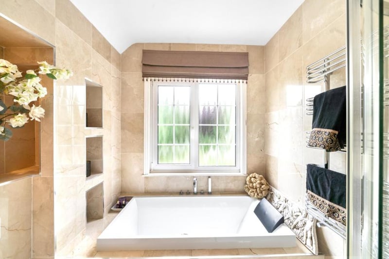 The bathroom is fully tiled with Italian marble and features underfloor heating.