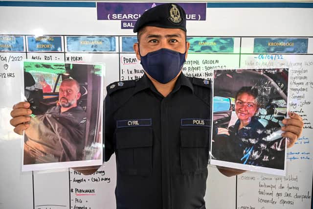 Mersing district police chief Cyril Edward shows pictures of two divers found alive, French national Alexia Alexandra Molina (R) and British national Adrian Peter Chesters (L), with a Dutch teen still missing, after a press conference in Mersing on April 9, 2022, during the search to locate three divers at sea after they went missing off Malaysia's southeast coast near Mersing in Johor state. (Photo by Mohd RASFAN / AFP) (Photo by MOHD RASFAN/AFP via Getty Images)
