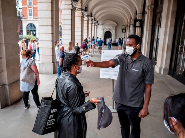 Security took the temperature of shoppers at an Apple store in Covent Garden in London before they entered.
