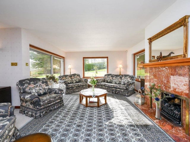 The living room is bright and spacious, and has a feature fireplace.
