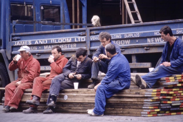 Workmen take a break for lunch in front of a James and Bloom lorry in Glasgow, August 1990.