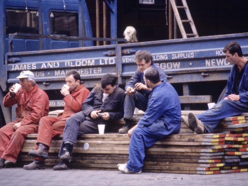 Workmen take a break for lunch in front of a James and Bloom lorry in Glasgow, August 1990.