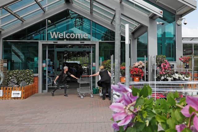 A member of staff greets a customer outside a garden centre (Photo by Adrian DENNIS / AFP) (Photo by ADRIAN DENNIS/AFP via Getty Images)