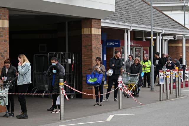Shoppers queue using social distancing outside a Tesco supermarket  (Photo by Oli SCARFF / AFP) (Photo by OLI SCARFF/AFP via Getty Images)