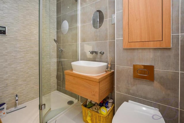 The attractive en suite to the master bedroom features a walk-in shower with digital thermostat. It is also blessed with full-height, contemporary tiling, a wall-hung basin, vanity unit, chrome fixtures and a low-flush WC.