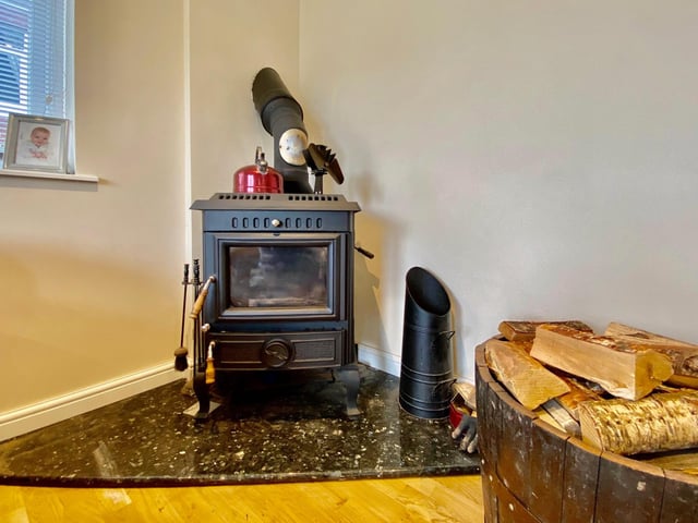 A log burner fire in the corner of the open-plan kitchen/diner.