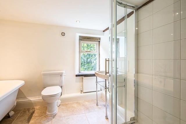 The bathroom has a freestanding tub and a separate shower enclosure.
