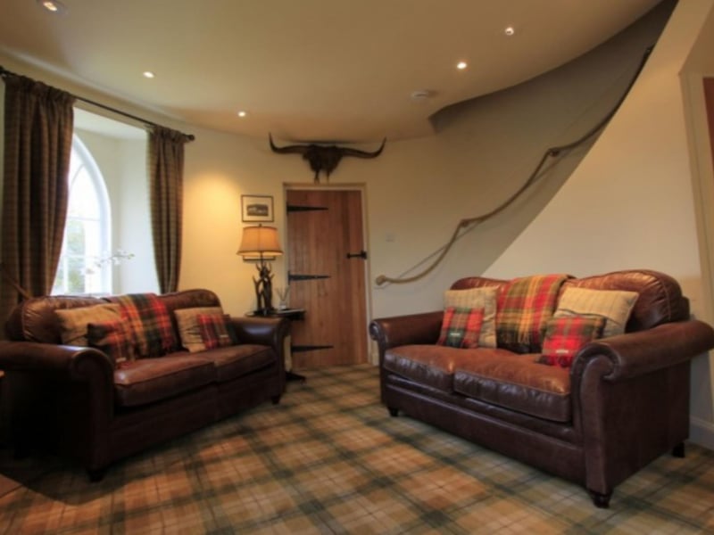 The living room has comfortable furniture, a television and a DVD player.