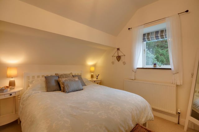 This is the second bedroom - to one wall, there’s a range of fitted furniture incorporating hanging and shelving.