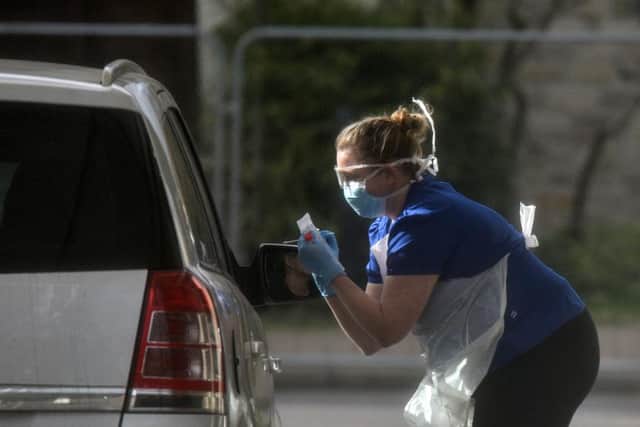 A nurse is seen swabbing the occupants of a car at a drive through COVID-19 testing station (Photo by Peter Summers/Getty Images)