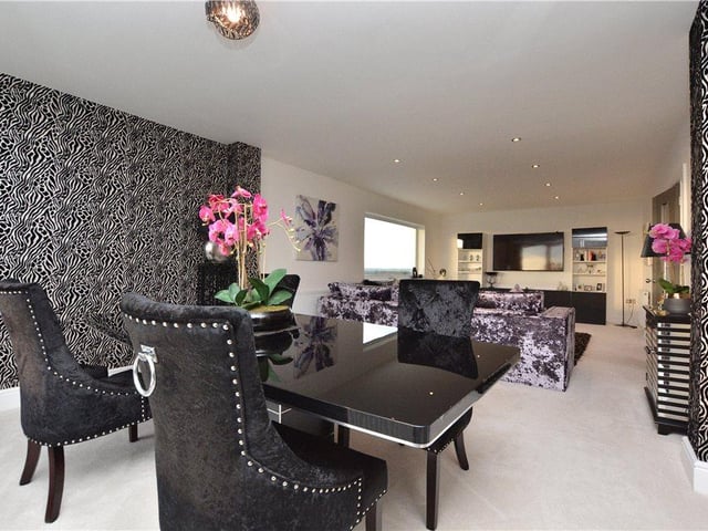 A formal dining room and lounge area sits adjacent to the kitchen, providing plenty of space for family meals and entertaining.
