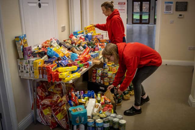 Members of staff organise food donations for vulnerable families at the Cooking Champions food bank in Grange Park, north London.