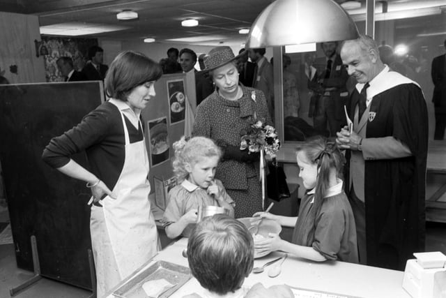 Queen Elizabeth II with two little girls in their cookery class at George Watson's school during the royal visit to Edinburgh in June 1982.